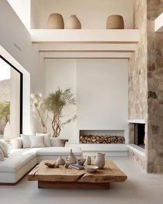 a modern living room with white furniture and stone fireplace