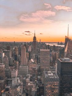 an aerial view of new york city at sunset with the empire building in the foreground