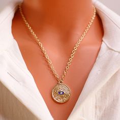 Drape yourself in the allure of our Indigo Eye Medallion Necklace, a captivating piece featuring a medley of colors and an exquisite gold-plated pendant and chain. 🌈✨ Crafted with attention to detail, the pendant embodies a blend of hues, bringing a touch of mystery and vibrancy to your ensemble. The gold-plated chain, with a length of 45 cm, adds a touch of elegance to this enchanting accessory. 📿💖 Wear this Indigo Eye Medallion Necklace as a symbol of unique style, drawing attention with it Bohemian Gold Pendant Chain Necklace, Gold Bohemian Pendant Chain Necklace, Bohemian Gold Medallion Chain Necklace, Bohemian Gold Chain Necklace Gift, Bohemian Gold Chain Necklace For Gift, Bohemian Gold Round Pendant Charm Necklaces, Gold Medallion Pendant Necklace With Clavicle Chain, Bohemian Gold Round Pendant Charm Necklace, Gold Chain Medallion Necklace For Gift