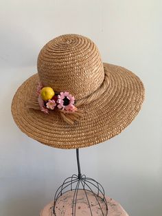 "This is a vintage 1950's straw sun hat. The hat is intricately woven with a braided section across the brim. There is also pink tone faux floral details. By the faux flowers there are also plastic faux fruit adding a pop of color and texture. The hat is in excellent condition. Measurements: Circumference: 21\" | Inside Depth: 5.5\" | Brim Depth: 4\" | Brim Circumference: 46\" Unless otherwise stated all vintage items are used and may have minor to moderate wear or discoloration considering the Summer Pink Straw Hat For Garden Party, Pink Summer Straw Hat For Garden Party, Adjustable Pink Straw Hat, Pink Straw Hat With Short Brim, Spring Braided Toquilla Straw Hat, Spring Pink Straw Hat, Pink Straw Fedora Hat, Pink Fedora Straw Hat, Handmade Bohemian Straw Hat For Garden Party