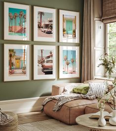 a living room with green walls and pictures on the wall above the couch, along with a coffee table