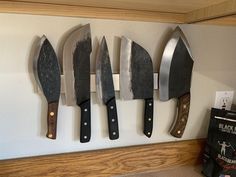 there are five knives hanging on the wall