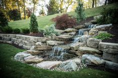 an outdoor waterfall in the middle of a garden