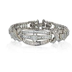 Elevate your jewelry collection with this exquisite Platinum Diamond Bracelet from the 1960s. Imbued with timeless elegance, this bracelet features a mesmerizing 1-carat center Emerald Cut diamond, captivating every gaze with its enchanting allure. Complementing its brilliance are approximately 20 carats of small round and baguette diamonds, meticulously set to create a harmonious display of sparkling radiance.Crafted in platinum, this bracelet showcases the superior craftsmanship of yesteryear, Luxury Palladium Hardware Bracelets For Formal Occasions, Luxury Estate Silver Jewelry, Luxury Sterling Silver Diamond-cut Bracelet, Luxury Silver Bracelet With Palladium Hardware, Luxury Art Deco Diamond Bracelet For Anniversary, Luxury Platinum Emerald Cut Diamond Bracelet, Classic Luxury Jewelry With Palladium Hardware, Luxury Platinum Diamond Bracelet With Emerald Cut, Luxury Estate Jewelry For Anniversary