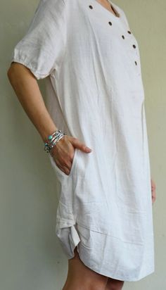 "A boho casual chic short sleeve cotton mix linen dress/tunic with curved hem. - Silhouette- - Loose fit body - Short sleeves - Pleated front dress - Curved hem - Hidden pockets in side seams of the dress - Body length - 94cm/37\" (longest part) Model is 161 cm. tall with the waist of 28\" and the hip of 38\" Status: ready to ship Weight: 302g Measurement: Tunic /dress (approximately) Shoulder: 16.25\" Bust: 42\" **can fit upto bust max38\" Armhole: 22\" Sleeve: 9\" Hip: 48\" **can fit upto bust Summer Linen Shift Dress With Short Sleeves, Casual Short Sleeve Mini Dress For Vacation, Beige Short Sleeve Summer Dress, Spring Linen Shift Dress With Short Sleeves, Short Sleeve Linen Dress For Beach, Beige Linen Short Sleeve Dress For Summer, Beige Short Sleeve Linen Dress For Summer, Casual Short Sleeve Summer Tunic, Summer Cotton Tunic With Short Sleeves