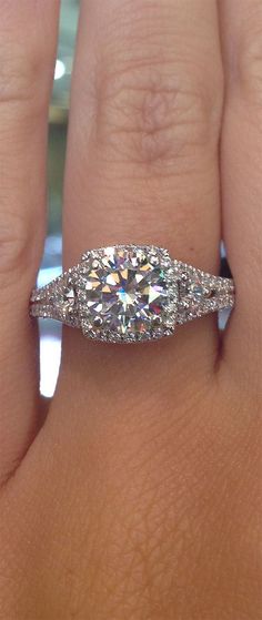 a woman's hand with a diamond ring on top of her finger and an engagement band