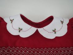 a red dress with white collars and holly embroidered on it