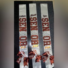 two ribbons with red bows on them sitting on top of a black countertop next to each other