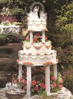 a three tiered wedding cake sitting on top of a table covered in pink flowers