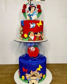 a three tiered cake with snow white and the seven dwarfs on it