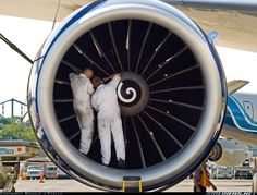 two men working on an airplane engine