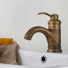 a gold faucet sitting on top of a white sink next to a towel