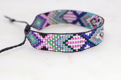 Introducing our adjustable southwestern beaded cuff bracelets! This colorful cuff bracelet is handmade with a southwestern-inspired pattern in shades of black, white, turquoise, coral, green, cobalt blue, and metallic pink. The bracelet is strung on strong beading thread and flexible beading cord with an adjustable closure, making it easy to put on and take off, while also allowing you to customize your fit. Whether you're dressing up for a special occasion or just accenting your everyday style, Painted Desert, Bead Loom Pattern, Beading Cord, Beading Thread, Beaded Cuff Bracelet, Beaded Bracelet Patterns, Southwestern Jewelry, Beaded Cuff, White Turquoise