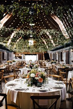 the tables are set with white linens and greenery