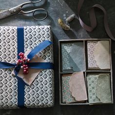 an open gift box sitting on top of a table next to scissors and other items