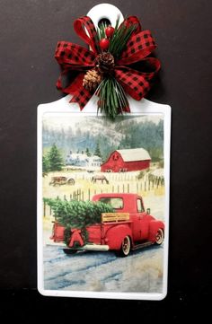 an old red truck with a christmas tree on the back is hanging from a wall