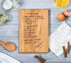 a wooden cutting board sitting on top of a table next to eggs and cinnamons