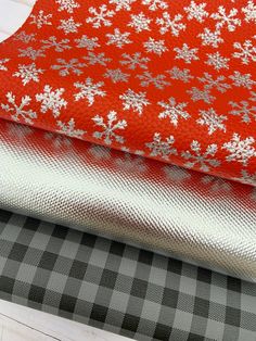 three different types of fabric with snowflakes on them, one red and the other grey