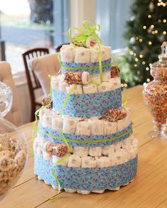 a large stack of diapers sitting on top of a table next to a christmas tree