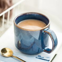 a cup of coffee and spoon on a table