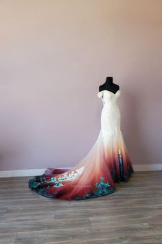 a wedding dress on display in front of a pink wall and wooden floored floor