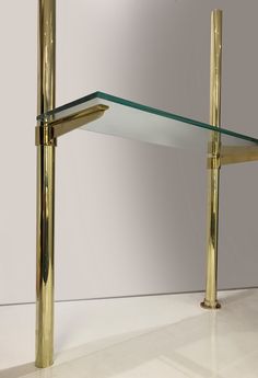 a glass and brass shelf with two shelves