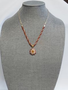 "Hand beaded flower with a large glass rhinestone in the center hangs on a gold bail. The chain is 21\" long and is made of an 8\" section of hand made gold and brown twisted beads, and 2 - 6\" sections of 14K gold plated chain. It has a gold colored lobster claw closure. It will arrive securely packed in an organza bag and a bubble envelope." Gold Beaded Necklaces With Flower Charm As Gift, Gold Beaded Necklaces With Flower Charm, Gold Beaded Necklace With Flower Charm For Gift, Gold Beaded Necklace With Flower Charm As Gift, Gold Flower Shaped Necklace With Beaded Chain, Gold Flower Necklace With Beaded Chain, Gold Beaded Chain Flower Jewelry, Gold Flower Beaded Chain Jewelry, Gold Flower Shaped Beaded Chain Jewelry