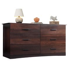 a large wooden dresser with drawers and a lamp on it's top shelf, against a white background