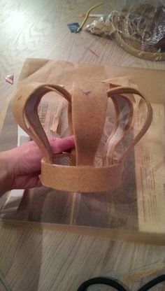 a person is making a paper crown out of cardboard