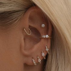 a woman with blonde hair wearing three different ear piercings