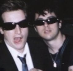 two young men in sunglasses are looking at something