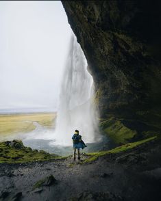 a person standing in front of a waterfall