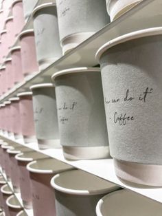 coffee cups with writing on them are lined up against the wall in front of each other