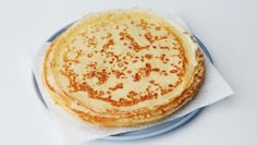 a stack of pancakes sitting on top of a blue plate next to a white napkin