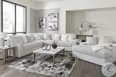 a living room filled with furniture and a rug on top of a hard wood floor