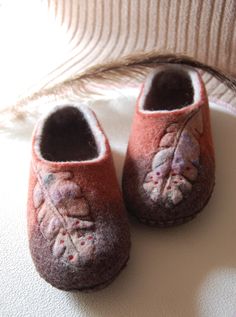 two pairs of baby shoes sitting on top of a white table