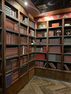 a room filled with lots of books on wooden shelves next to a wall mounted clock