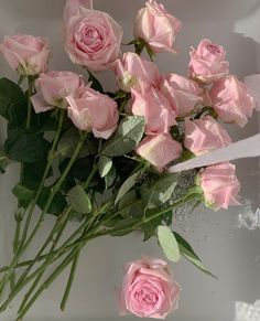 a bouquet of pink roses sitting on top of a table