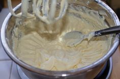 a mixing bowl filled with batter and a whisk on top of the mixer