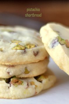 three cookies with pistachio and white chocolate chips are stacked on top of each other