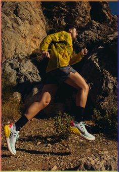 a man is running in the mountains with his feet up and one leg on the ground