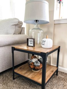 a living room with a couch, table and lamp on top of the coffee table