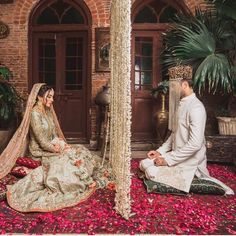 a bride and groom sitting on the floor in their wedding outfits