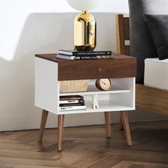 an end table with books and a lamp on top