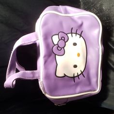 a purple hello kitty purse with a bow on it