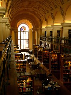 an empty library with tables and bookshelves filled with lots of books in it