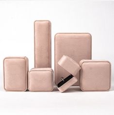 four pieces of pink leather sitting next to each other on a white surface with one piece in the middle