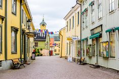 an empty street with benches and buildings on both sides, in the middle of town