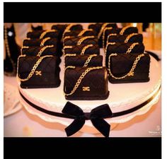 a table topped with lots of chocolate cakes covered in gold chains and black bow ties