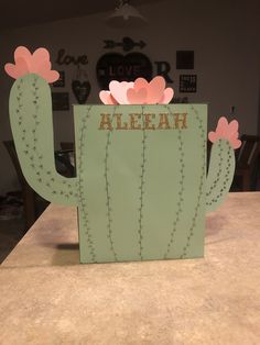 a cactus shaped card with the word aleah written on it and flowers growing out of it